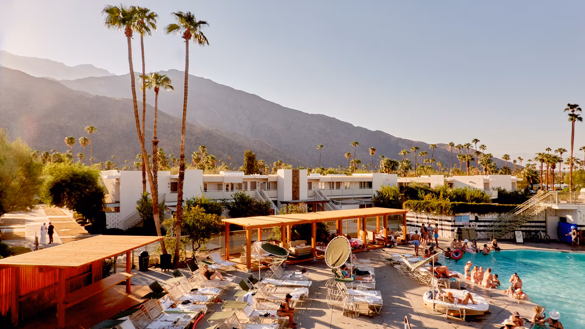 a pool with lounge chairs and a mountain in the background